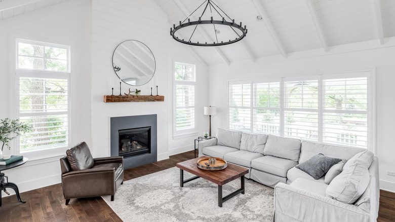 Living room with shiplap, exposed beams, and wood flooring