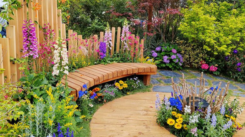 Wood seat in a colorful garden