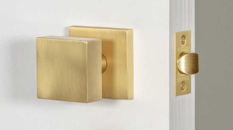 Gold square door knob in white door