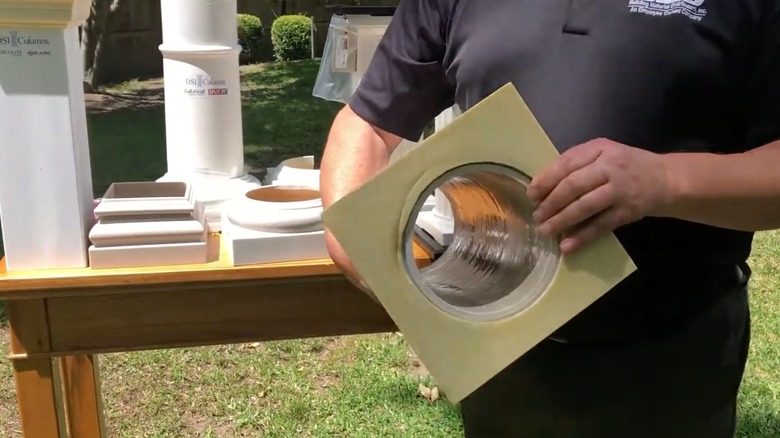 Person holding a fiberglass column showing the hollow inside