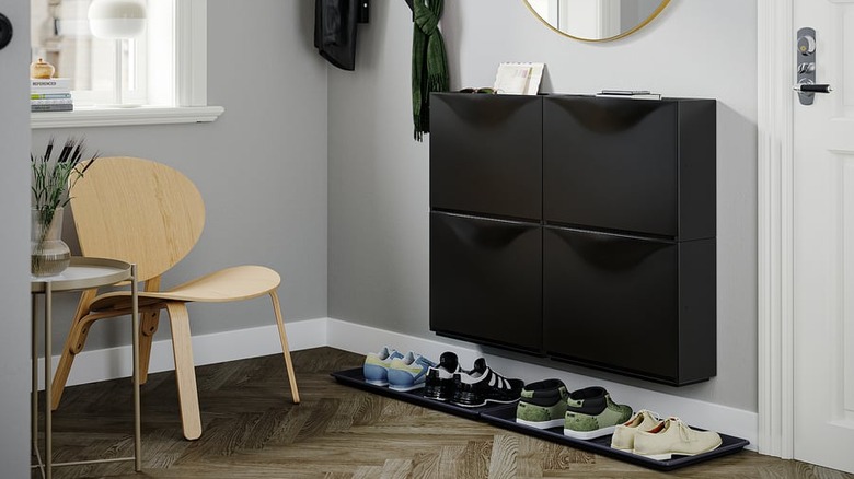 A small entryway with IKEA TRONES shoe cabinets and BAGGMUCK shoe trays.
