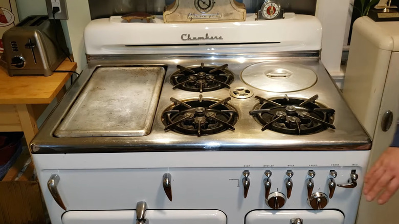 A restored vintage Chambers gas stove with three burners, a ThermoWell, and a stovetop griddle.