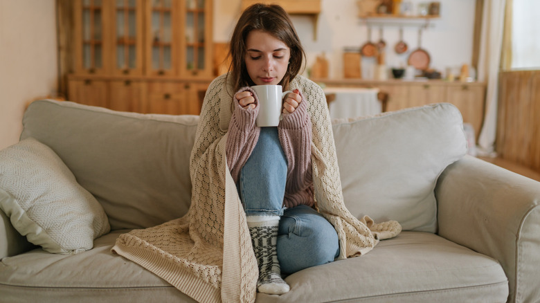 woman in a blanket sipping tea