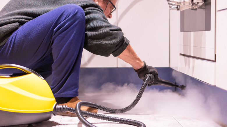 A man steam cleaning a floor