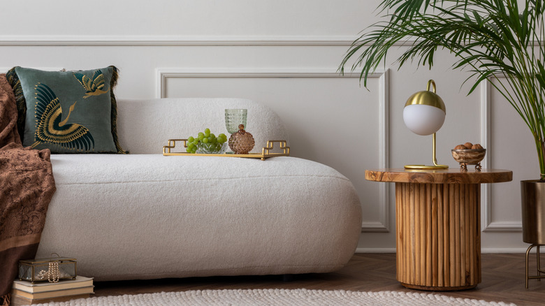 art deco living room with boucle sofa, wooden coffee table, and plant