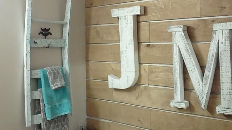 The upcycled towel rack hanging on the bathroom wall