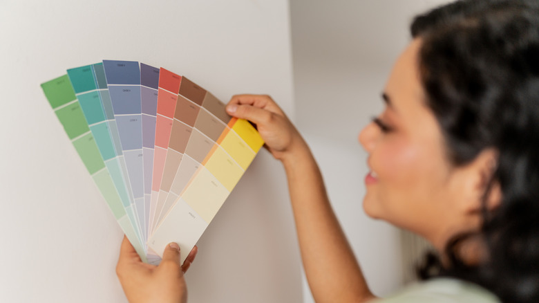 A woman holding and looking at color swatches