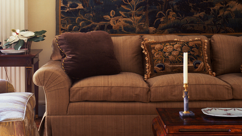 Living room with warm blue and orange landscape tapestry hung behind sofa