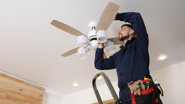 man installing ceiling fan