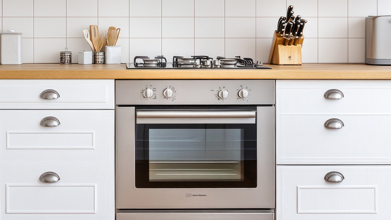 A stainless steel oven in a white kitchen