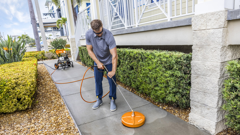 A person using a Stihl backpack leaf blower in a park