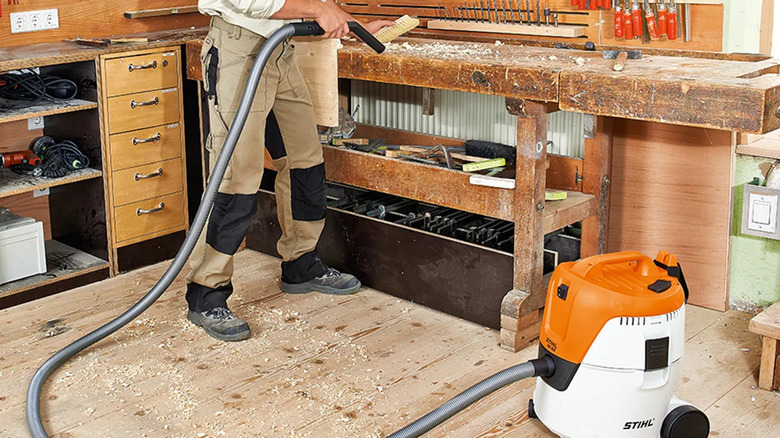 A person cleaning a workshop with Stihl's SE 62 Electric Vacuum Cleaner