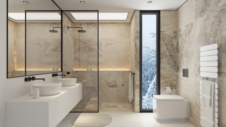 A luxurious bathroom with a marble wall and waterfall shower head