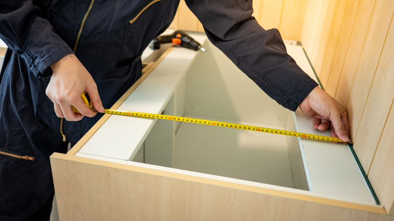 Workman measuring countertop