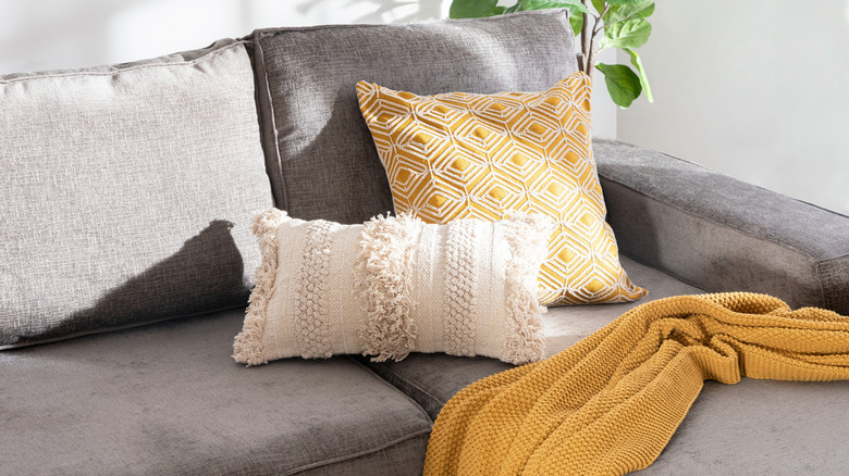 Close up photo of a few decorative throw pillows sitting on a couch