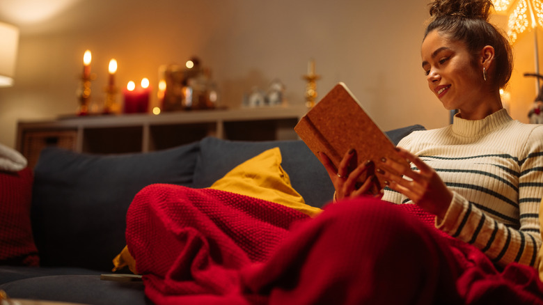 A person cozied up with blanket in living room