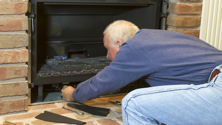 Man working on fireplace in home
