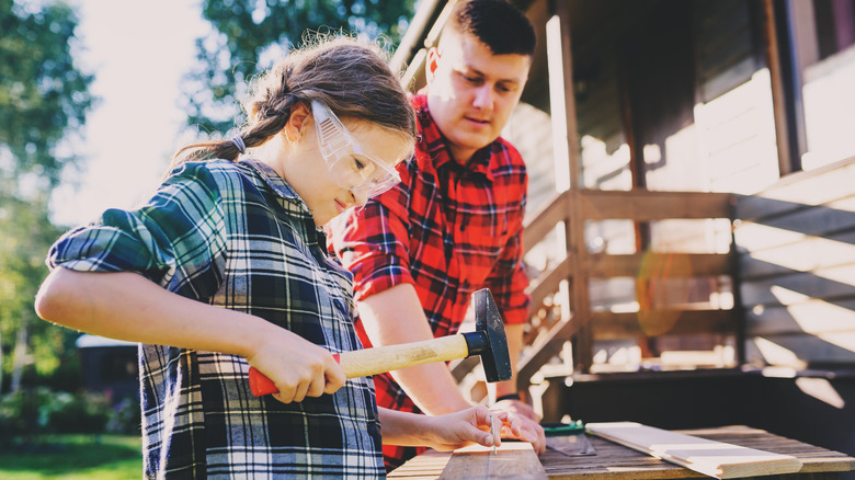 Father teaching his daughter how to use a hammer