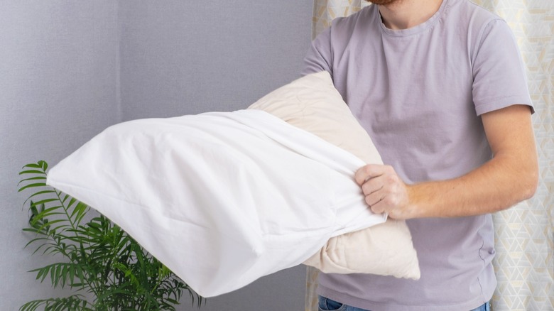 Man pulling pillowcase on pillow