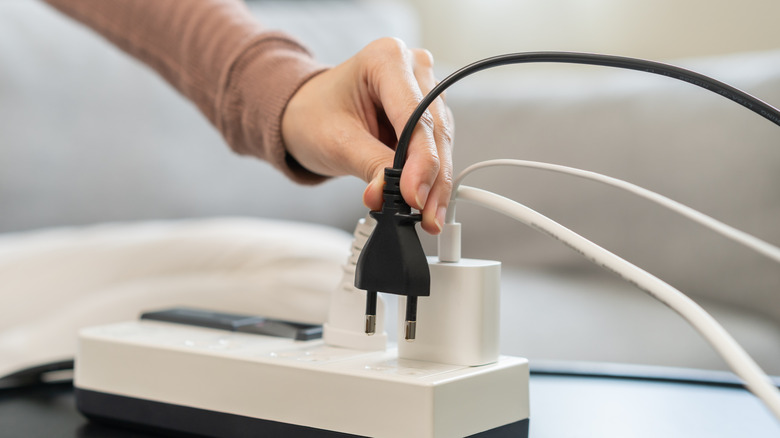 Someone unplugging a cord