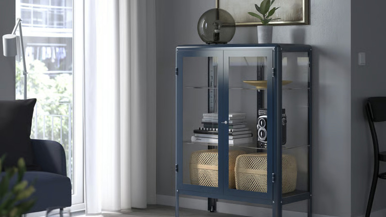 Light blue storage cabinet with decorative items inside