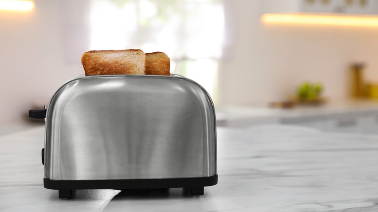 A steel toaster on a kitchen countertop.