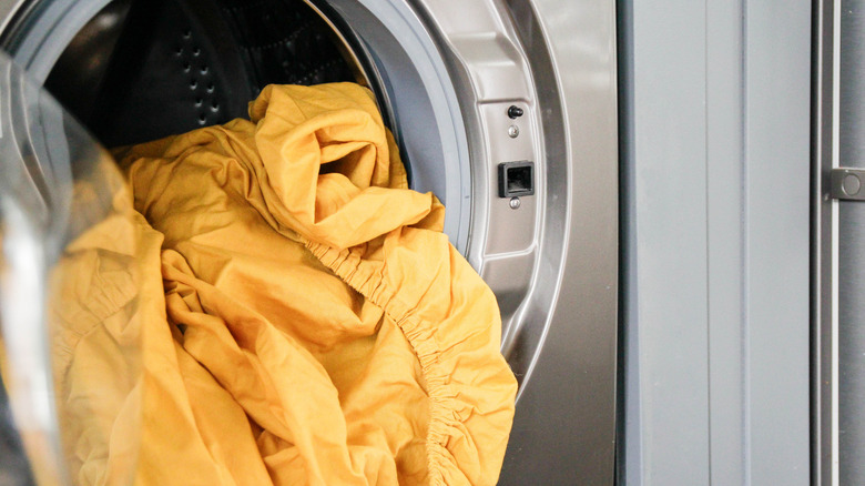 Set of yellow sheets sticking out from dryer door