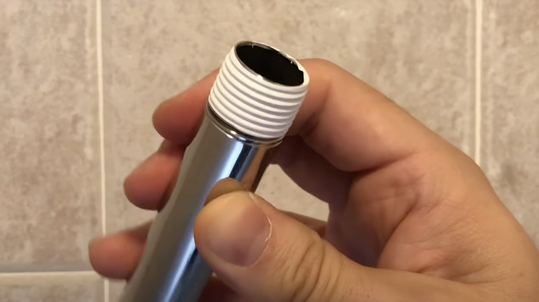Plumber's tape wrapped around shower arm thread