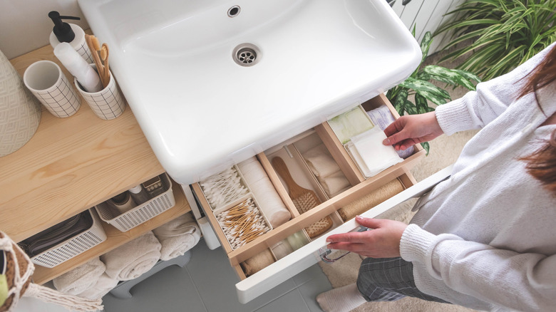 Woman opening bathroom drawer