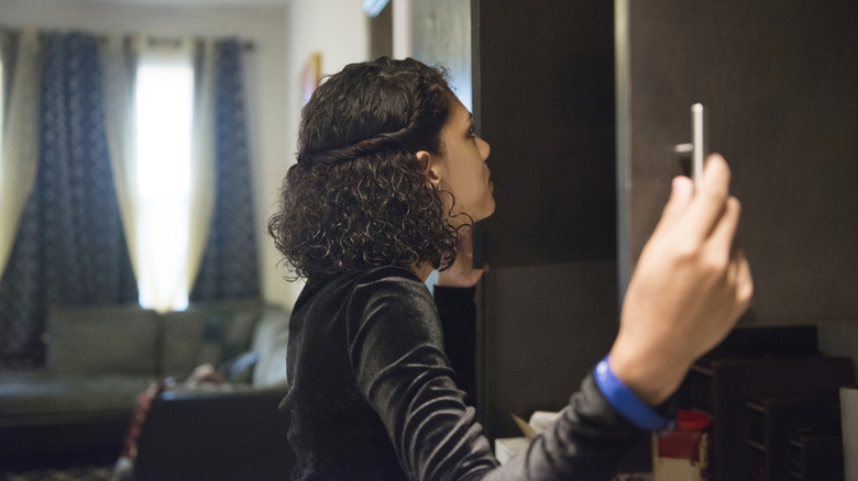 Woman looks in an empty cupboard, deciding how to turn it into paperwork storage without adding shelves.