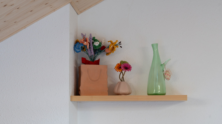 Floating shelves in a wall display several vases