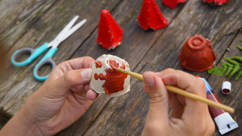 Hands painting a cone from an egg carton