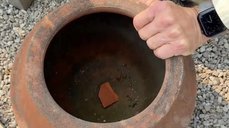 Piece of terracotta covering hole in pot