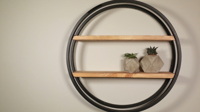 Wall-mounted shelf made from two bike rims and pine board