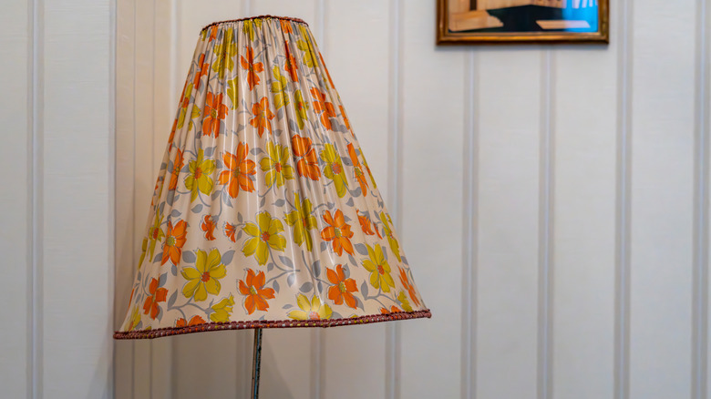 A vintage lampshade with orange and yellow flowers