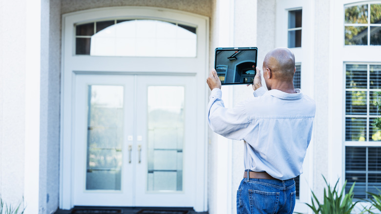 A person takes a photo of their front door to help them reconsider the design.