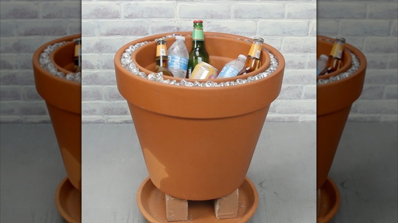 DIY terracotta pot beverage cooler filled with water bottles, beer, and sparkling water