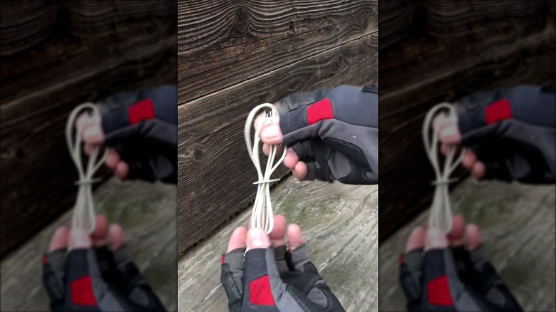Hands holding a charging cable with a bread tag on it to keep the cable together
