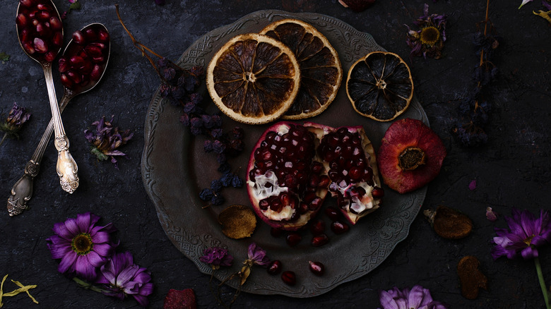 Plate with dried citrus slices, flowers, berries, and pomegranate