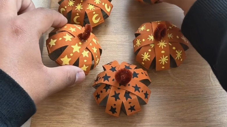 Mini pumpkins made from painted toilet paper rolls cut and formed into shape