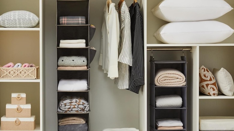 Two hanging closet organizers being used for clothes and other linens