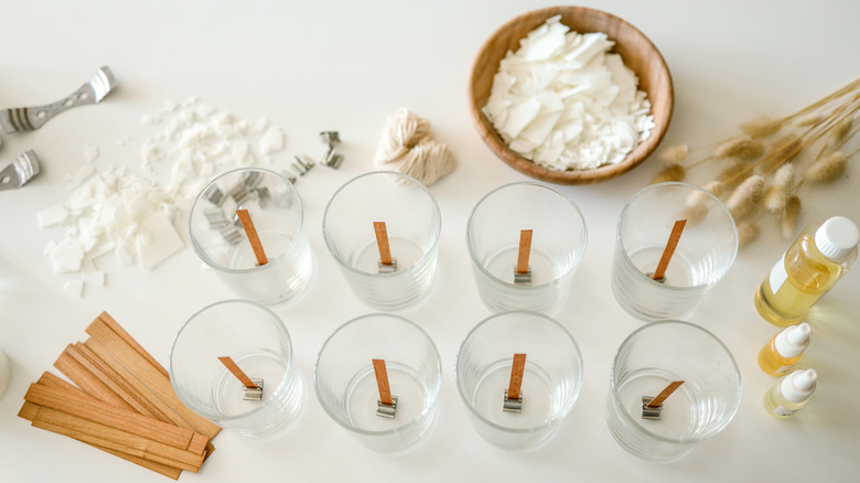 Wax shavings, essential oils, and wick-centered glass containers for candle making