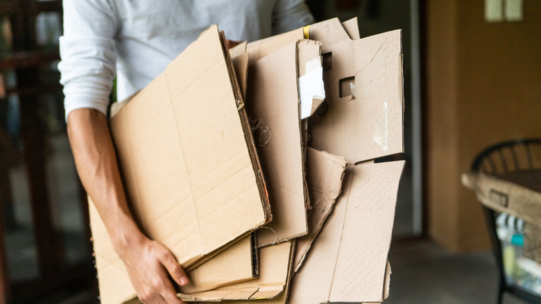 Person carrying folded recycled cardboard