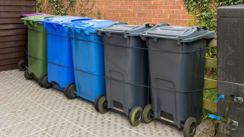 Trash cans secured in place with bungee cords