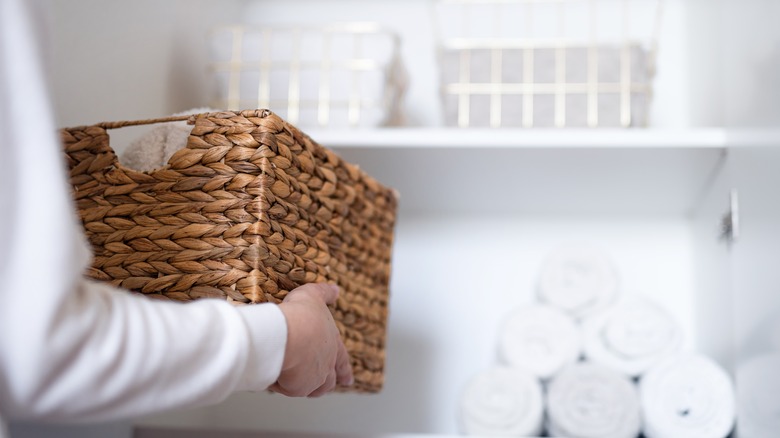 Person putting a basket on a shelf