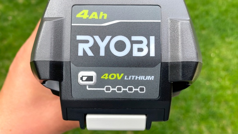 Person's hand holding 40v Ryobi rechargeable battery
