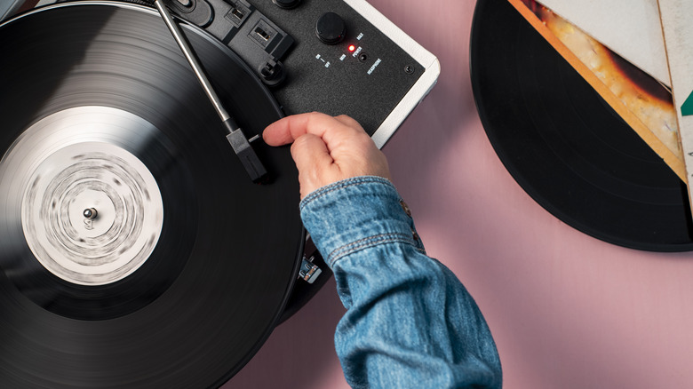 Woman putting a vinyl record on with a turntable