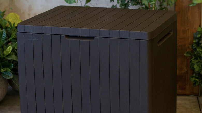 Outdoor patio storage box made of brown resin material