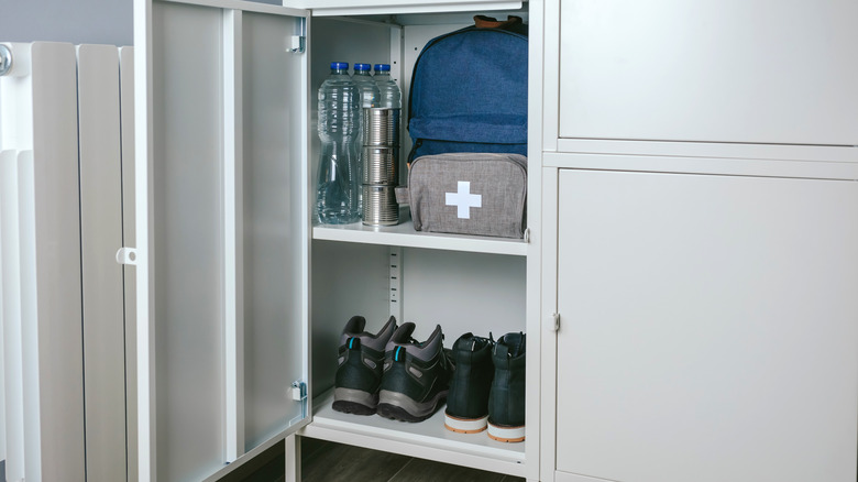 Gray first aid kit in a storage area on a shelf above shoes