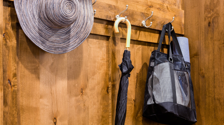 Umbrella hanging on a hook on a wood-paneled wall
